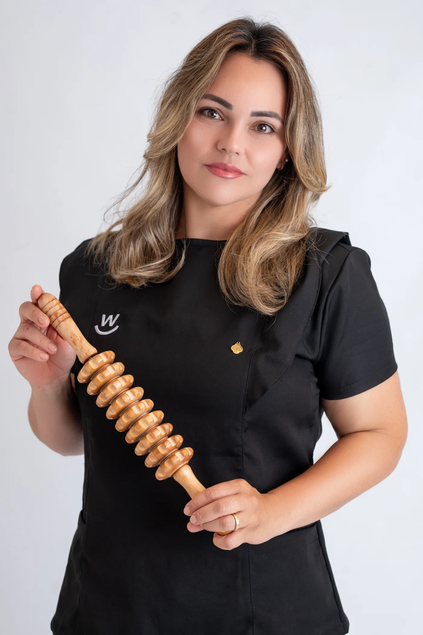 Esteticista segurando o rolo de madeira que usa nos atendimentos